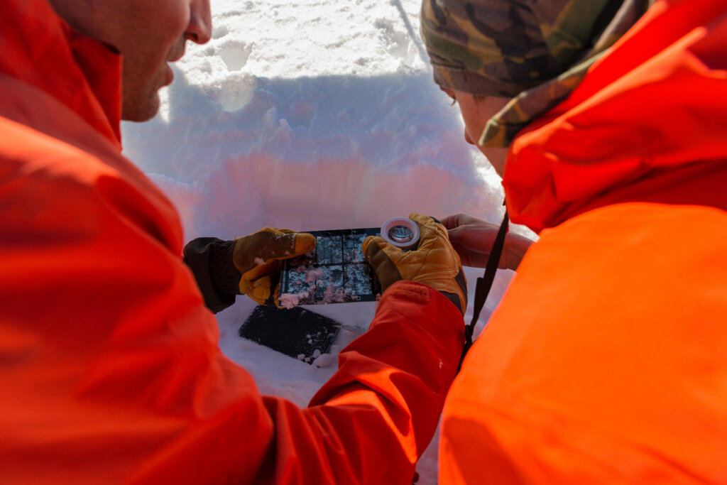 Fabiano Monto und Mirko Frigerio - Praktikant beim Livigno Avalanche Center - analysieren die Korngröße von Schneekristallen. Foto: Daniele Castellani.